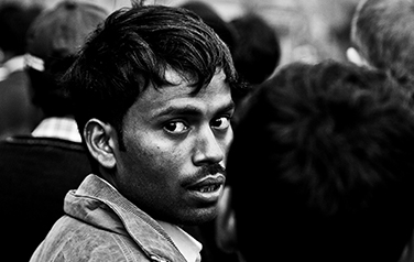 Indian man standing in line looking over shoulder